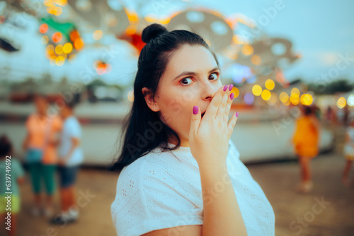 Young Girl afraid of the Fairy Wheel at the Amusement Park. Woman feeling nauseated after a ride at the carnival 