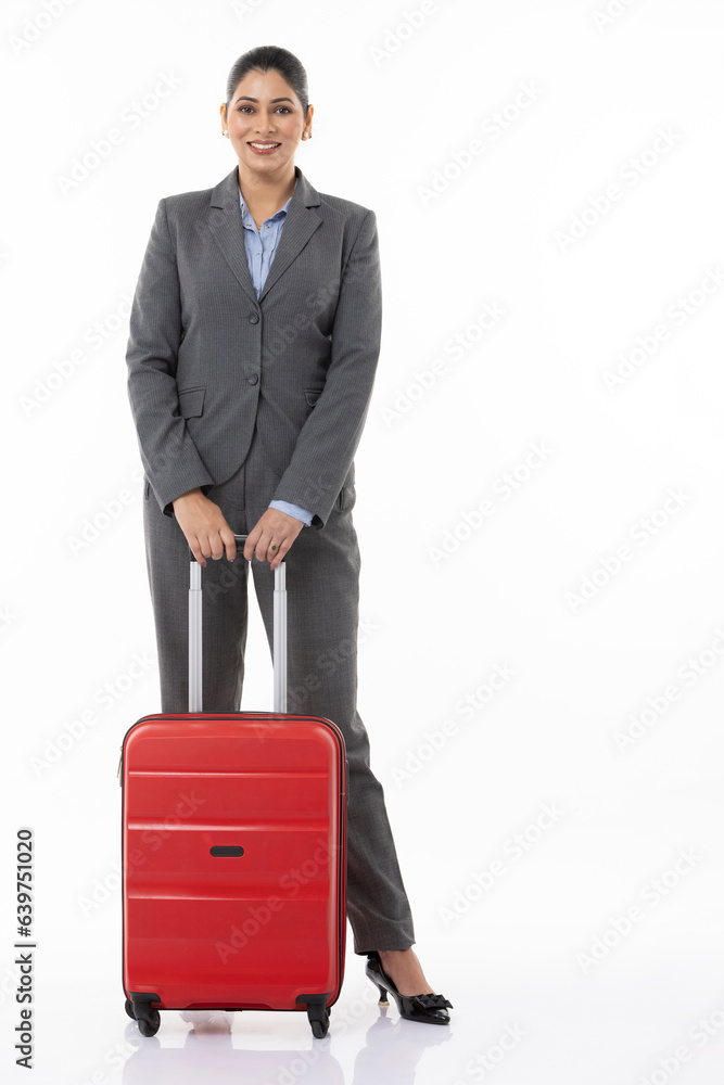 Full length of confident female professional manager with suitcase and standing against white background. Full length of confident female professional manager with suitcase and standing against white background.