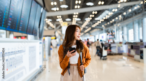 Fotografie, Obraz Young asian woman in international airport, using mobile smartphone and checking