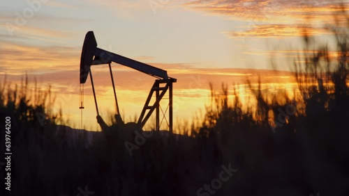 Silhouette of oil pump working at dawn in Vernal, Utah countryside, slow motion photo