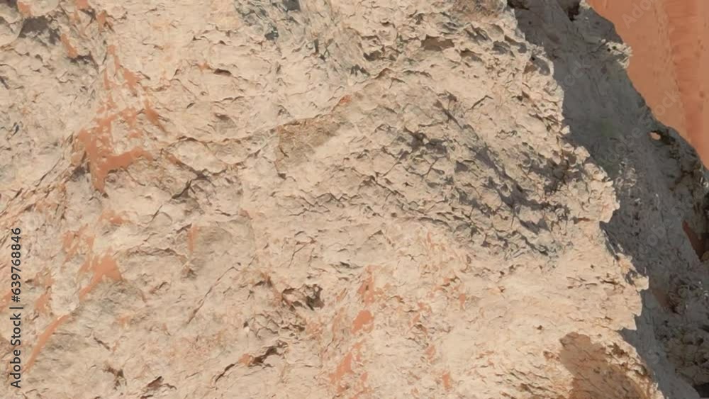 A drone flies around a young woman in a red dress standing on a cliff in the middle of the desert sands A drone flies around a young woman in a red dress standing on a cliff in the middle of the desert sands