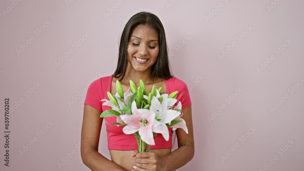 Young latin woman smiling confident holding bouquet of flowers over isolated pink background Young latin woman smiling confident holding bouquet of flowers over isolated pink background