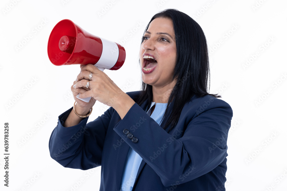 Female professional dressed screaming into megaphone while standing against white background Female professional dressed screaming into megaphone while standing against white background