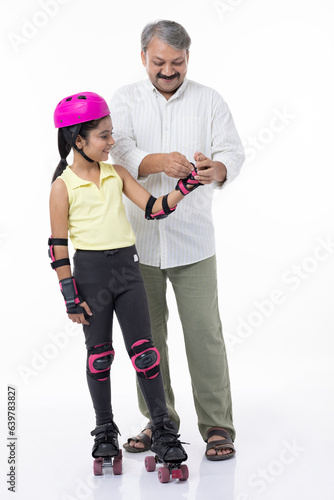 Father helping little daughter skating on roller skating  isolated on white background.