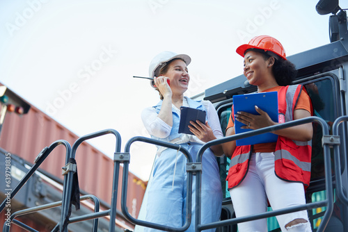 worker or engineer talking about work and project with businesswoman in containers warehouse storage