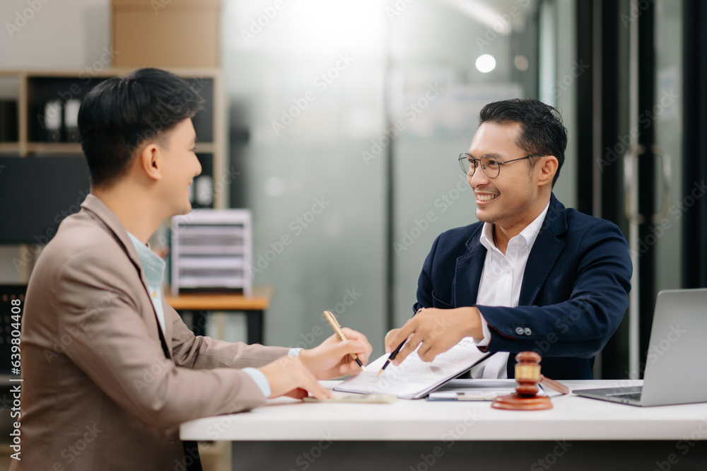 Two lawyers are discussing about contract paper, law matters determination, pointing.law and hammer on the table Two lawyers are discussing about contract paper, law matters determination, pointing.law and hammer on the table