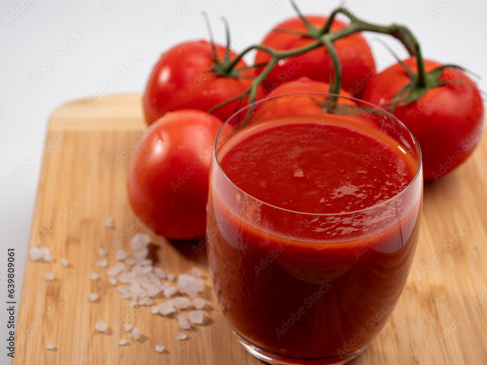 Glass of tomato juice and tomatoes on a white background. Freshly prepared tomato juice. Glass of tomato juice and tomatoes on a white background. Freshly prepared tomato juice.