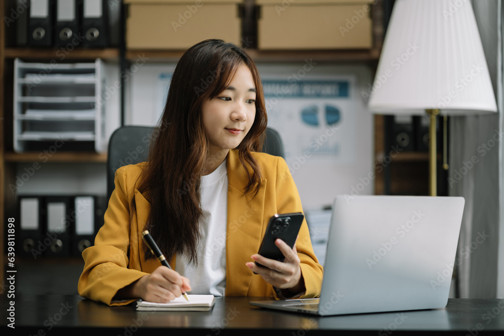 Business woman sitting at table using mobile phone, online working on laptop, searching the information on internet network. Business woman sitting at table using mobile phone, online working on laptop, searching the information on internet network.