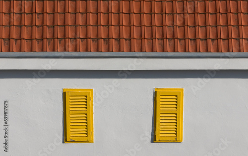 Old Retro Buliding with Terra Cotta Roof and Yellow Window Shutters photo