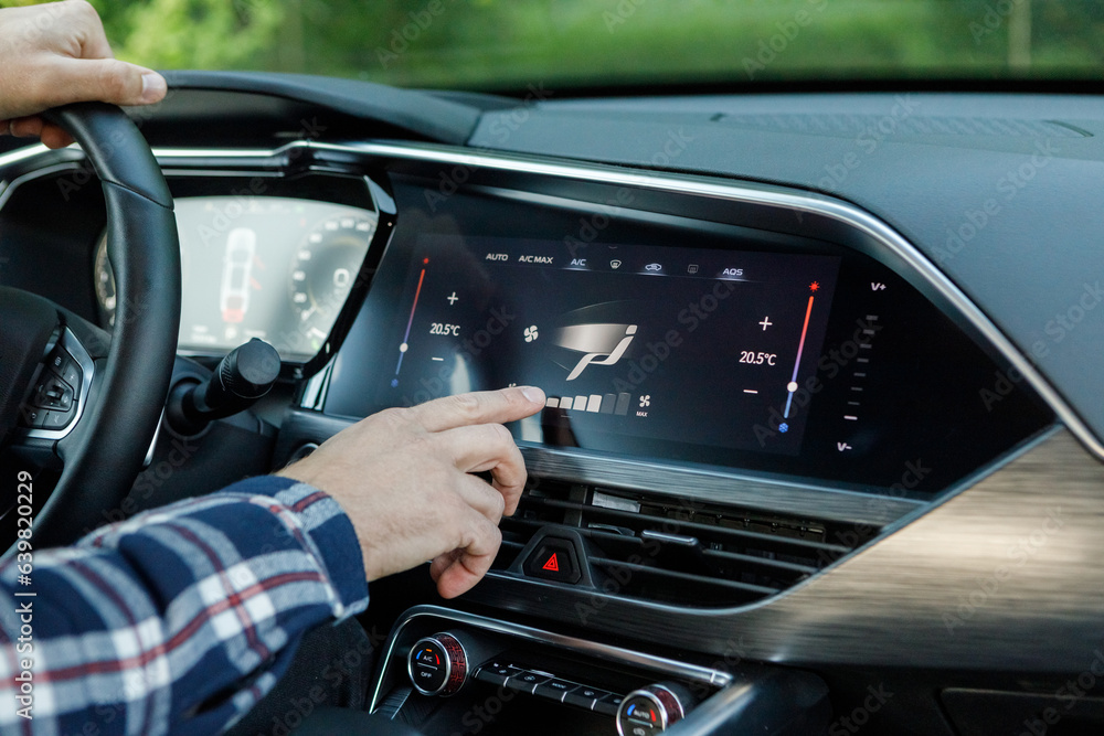 a man in an expensive new SUV uses a car multimedia with a touchscreen	