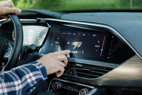 a man in an expensive new SUV uses a car multimedia with a touchscreen 