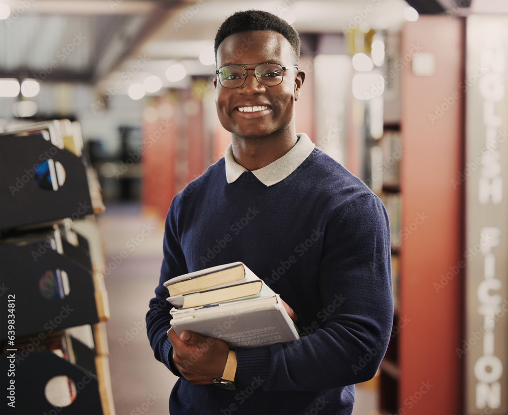 Fototapeta premium Student, university and portrait of black man in library for learning, education and reading books. Academy, college and happy African person with textbooks for research, school project and studying