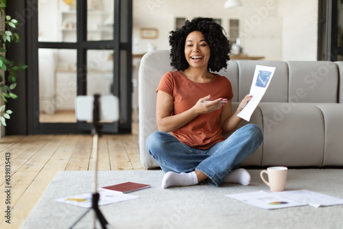 Free Download Teleconference Concept. Black woman making video call, showing documents at smartphone webcam - GFXLoad