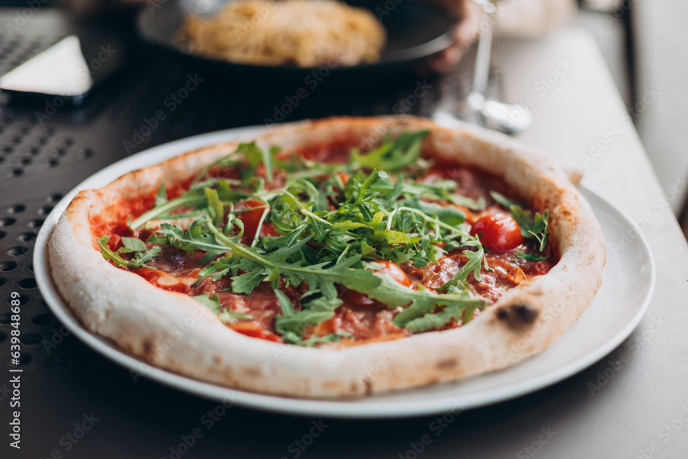 Fresh pizza with tomato, arugula and cheese on a dark table. Food banner