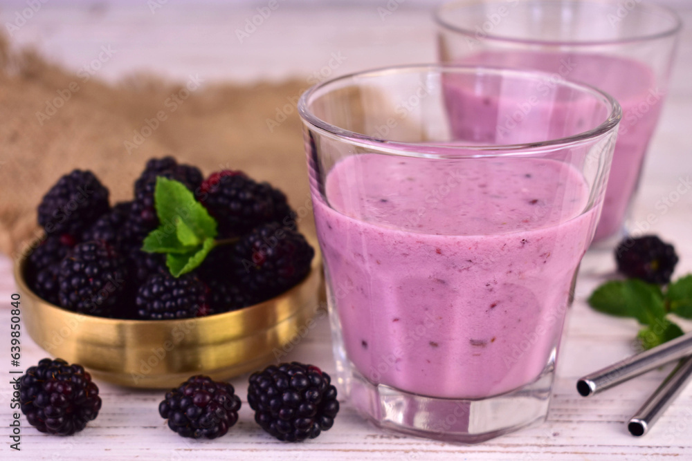 Homemade smoothie with fresh blackberries on a white wooden background.
Homemade smoothie with fresh blackberries on a white wooden background.