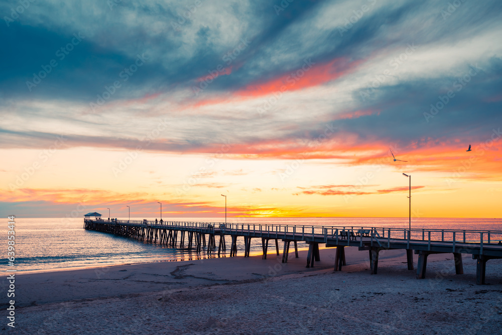 Henley Beach jetty at dusk with the tranquil sea embracing the weathered pillars