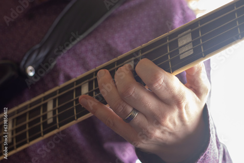 fingering a base guitar