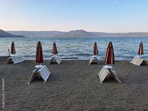 Beach with closed sunumbrellas and sunbeds photo