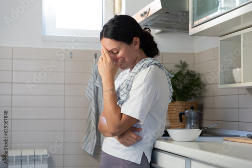 A housewife girl, tired, rubs the stove with gloves. Household routine woman labor