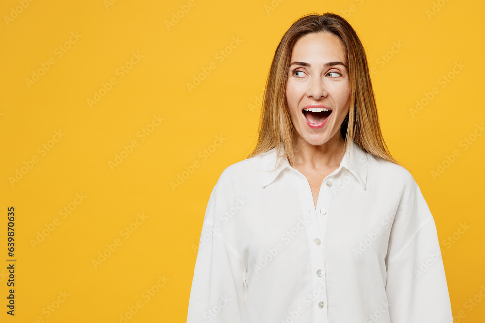 Φωτογραφία Young surprised shocked cool fun caucasian happy woman she wears white shirt casual clothes look aside on area with opened mouth isolated on plain yellow background studio portrait