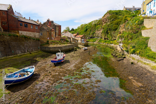 Картината върху платно Fishing boats resting on the bed of Staithes Beck at low tide.
