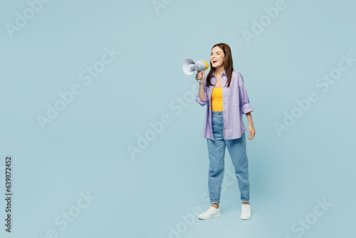 Full body young happy woman she wears purple shirt yellow t-shirt casual clothes hold in hand megaphone scream announces discounts sale Hurry up isolated on plain pastel light blue background studio. © ViDi Studio