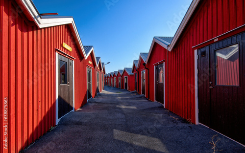 Wooden red boat, fisherman huts in row in Donsö, Gothenburg archipelago, Sweden on a sunny day
