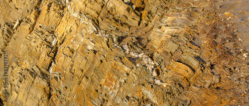 Orange rock texture. Texture of yellow ocher stone, a layer of white marble. Close-up of the Vendée reef. Backdrop, Nature.

