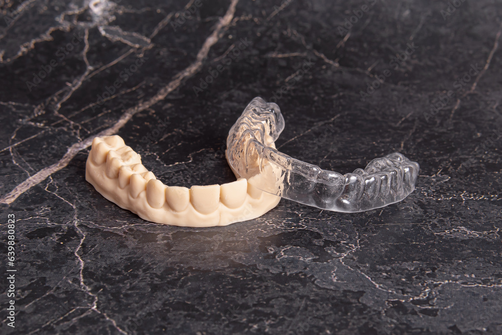 Aligners for teeth alignment and plastic jaw model. Black background
