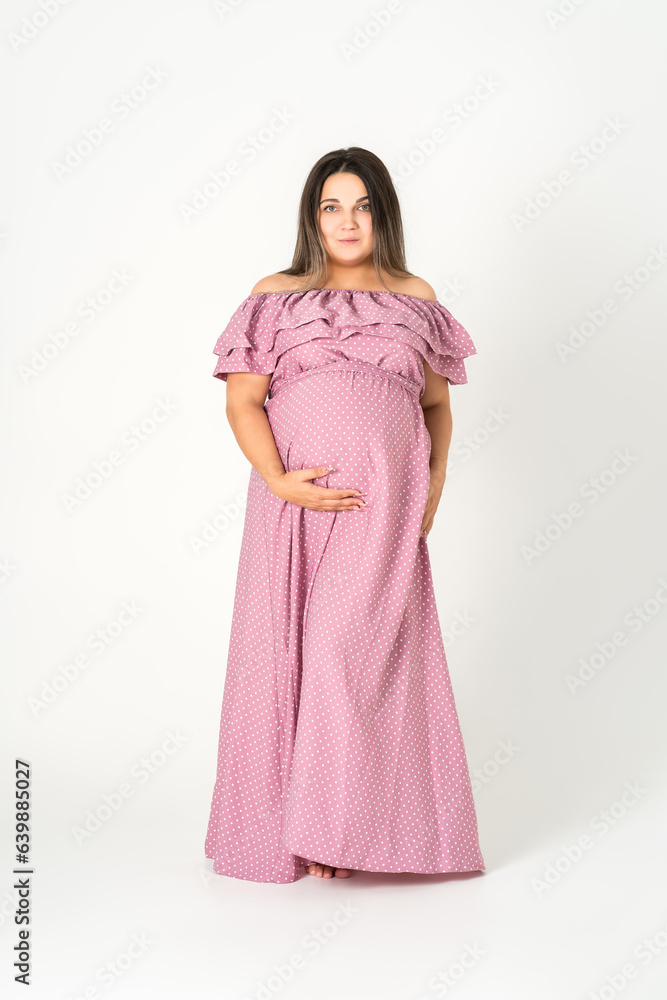 Plus size pregnant woman in dress on gray background, maternity clothes, pregnancy concept Plus size pregnant woman in dress on gray background, maternity clothes, pregnancy concept
