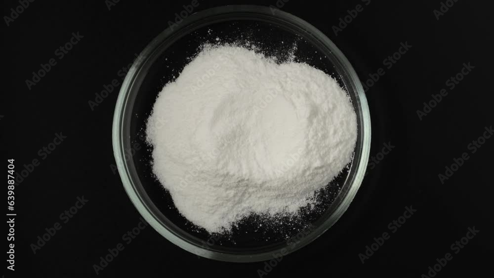 Food additive E363. Succinic acid in Petri dish, top view. Dicarboxylic acid. Spirit of amber, white powder. Flavoring agent, contributing a somewhat sour and astringent component to umami taste. Food additive E363. Succinic acid in Petri dish, top view. Dicarboxylic acid. Spirit of amber, white powder. Flavoring agent, contributing a somewhat sour and astringent component to umami taste.