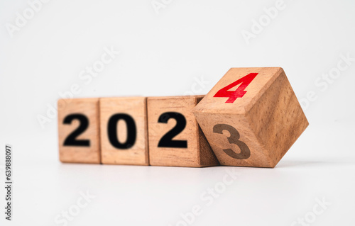 Obraz na plátne Flipping of 2023 to 2024 on wooden block cube for preparation merry Christmas and happy new year change and start new business target strategy concept
