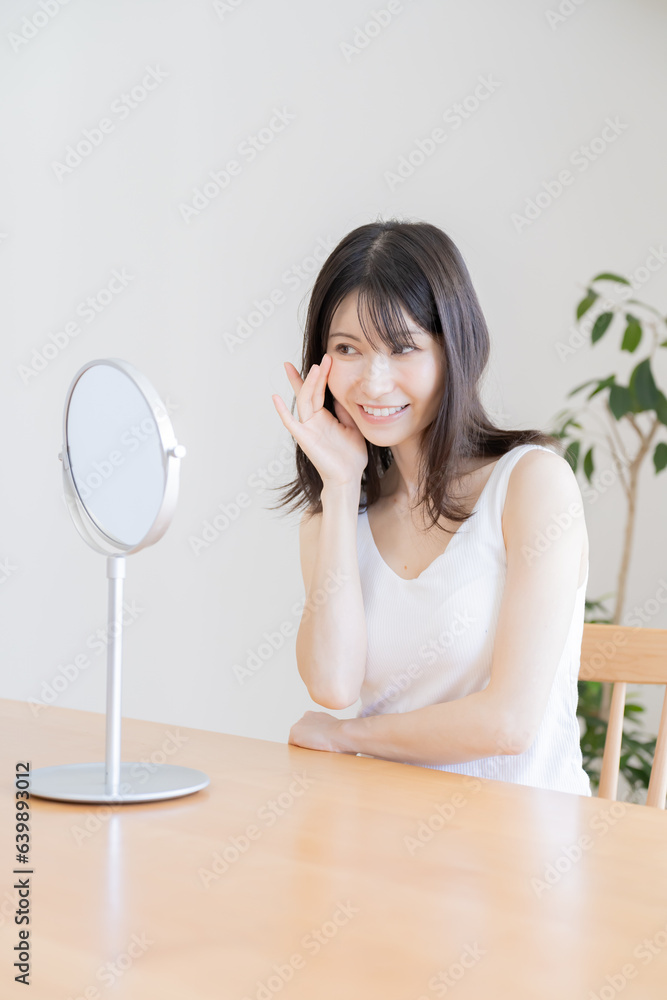 鏡を見て笑う日本人女性