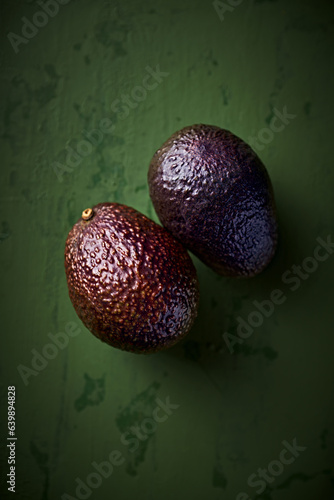 Hass avocado on green rustic background. Top view