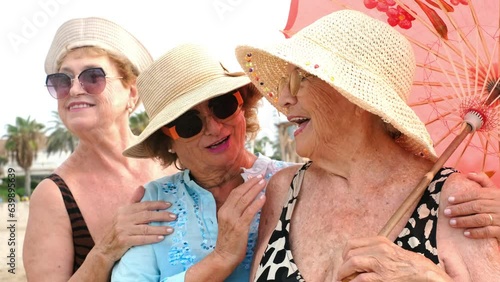 Group of ladies friends enjoy time and outdoor leisure activity together at the beach like tourist on summer holiday vacation. Concept of youthness and age. Retired ladies talking and enjoying time photo