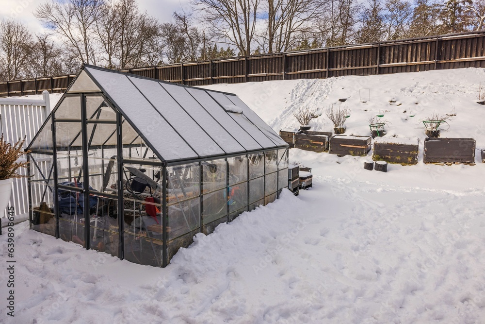 Gorgeous winter view of small garden and greenhouse with collected things for winter. Gardening concept. Sweden. Gorgeous winter view of small garden and greenhouse with collected things for winter. Gardening concept. Sweden.