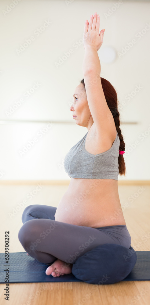 Pregnant woman does yoga in the gym Pregnant woman does yoga in the gym
