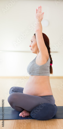 Pregnant woman does yoga in the gym