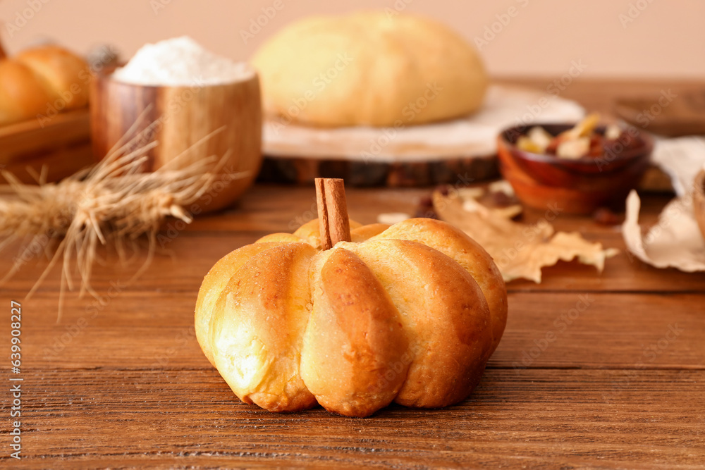 Tasty pumpkin shaped bun on table