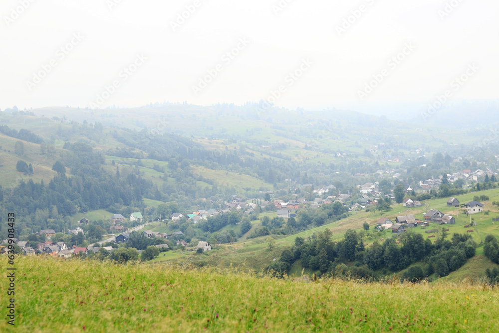 Landscape of Zakarpattia Oblast, Ukraine, Yasinya, view from the hill. Fog in the Carpathians, houses and plots