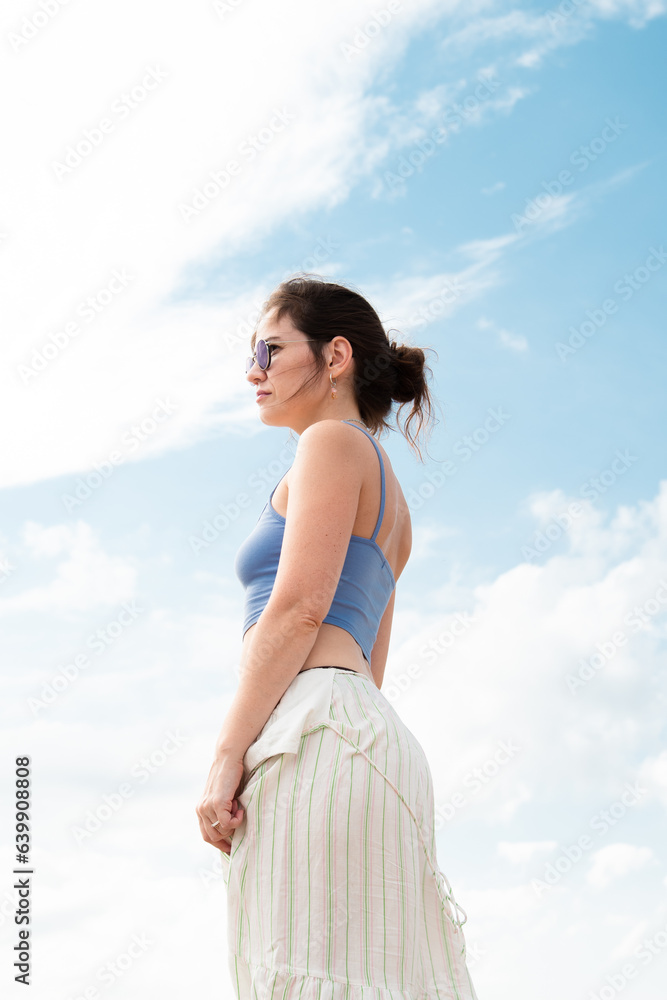 Beautiful young brunette in sunglasses against the sky Beautiful young brunette in sunglasses against the sky