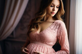 Closeup of pretty young pregnant woman with pregnancy belly in soft elegance pink clothes 