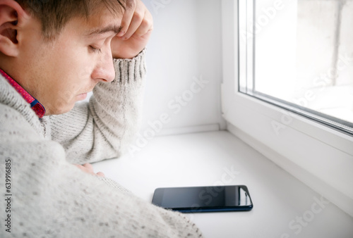Sad Young Man with a Phone