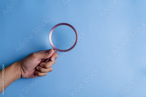 searching, securing, magnifier, icon, man, hand, blue, assurance, family, background. hold a magnifier to searching or find something at blue background. not has icon and symbolic isn't show.