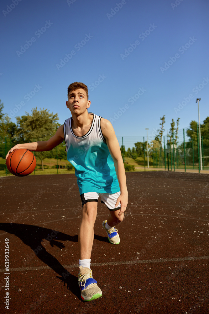 Young teenager training on street court playing basketball Young teenager training on street court playing basketball