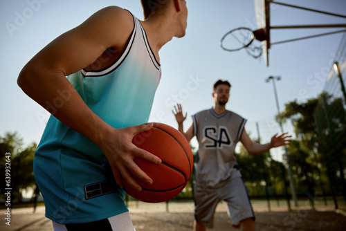 Closeup teenager son preparing to throw ball into basket hoop