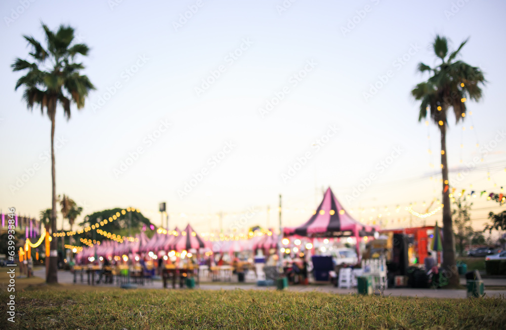 Fototapeta premium Blur image of flea market and food fair in Chiang mai city of Thailand. Also called festive food, street food. Marketplace consist of booth tent, shop, vendor and food stall. Busy with people.