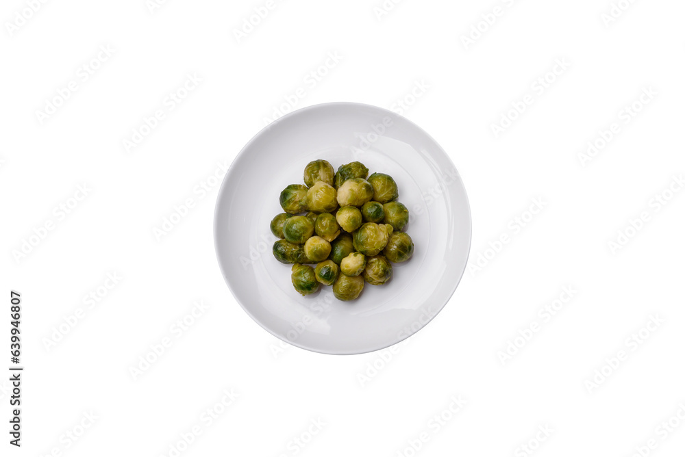 Delicious boiled Brussels sprouts on a ceramic plate on a dark concrete background Delicious boiled Brussels sprouts on a ceramic plate on a dark concrete background