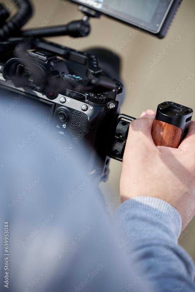 A man makes a video filming with a digital camera, which he holds in his hands.