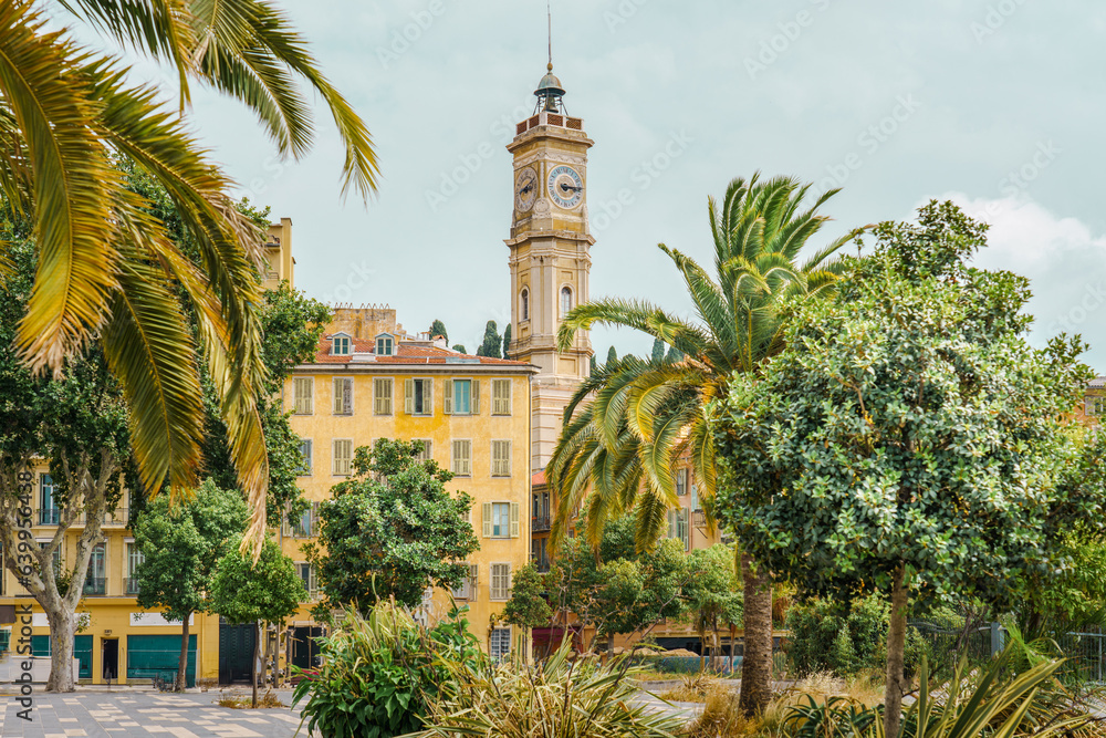 Center of a european city on the mediterranean sea. Old architecture and green palm trees.